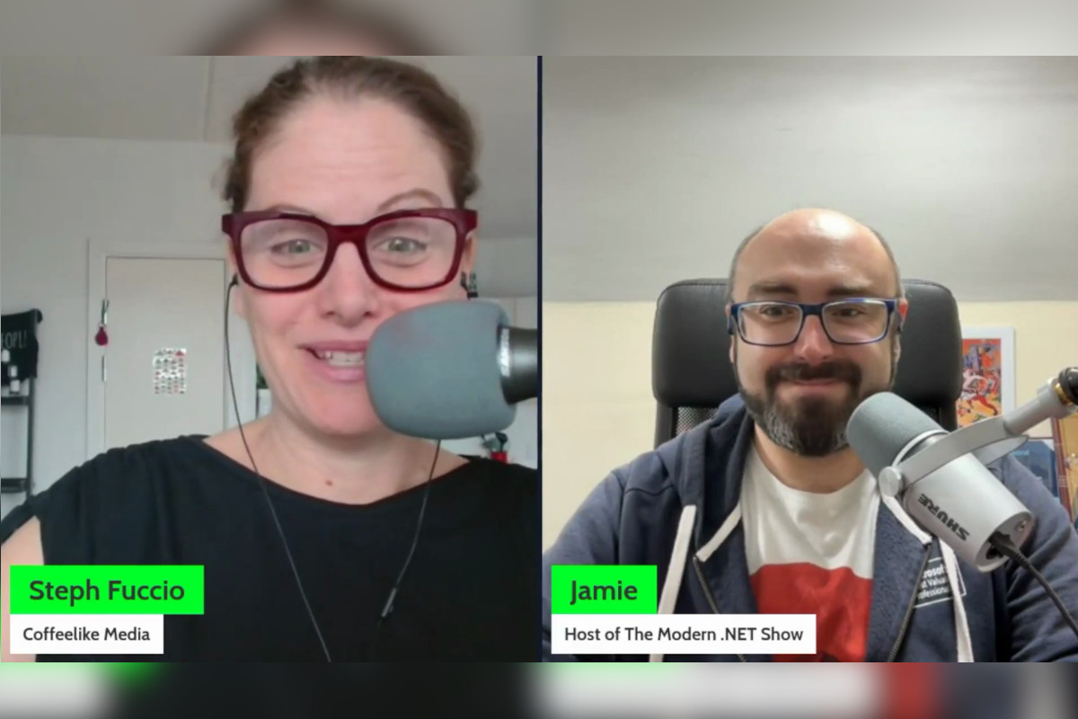 The image appears to be a screenshot from a video interview. There are two people visible in the image: on the left is a woman with glasses, wearing a dark top; and on the right is a man with glasses, a beard. Both individuals seem to be engaged in a discussion, as indicated by their focused expressions and posture. The image contains two text overlay elements, one per person: one says 'Steph Fuccio,' indicating the name of the woman on the left, and the other is a web address 'Jamie Taylor,' indicating the name of the person on the right. The setting appears to be an indoor space, possibly an office, with white walls and a window in the background. The overall style of the image seems candid and informal, typical of a casual video call or interview. 
