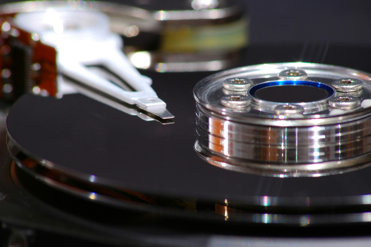A close up of a traditional, spinning, hard drive. The outer case has been removed, revealing the platters (which spin when powered up) and the read/write head.