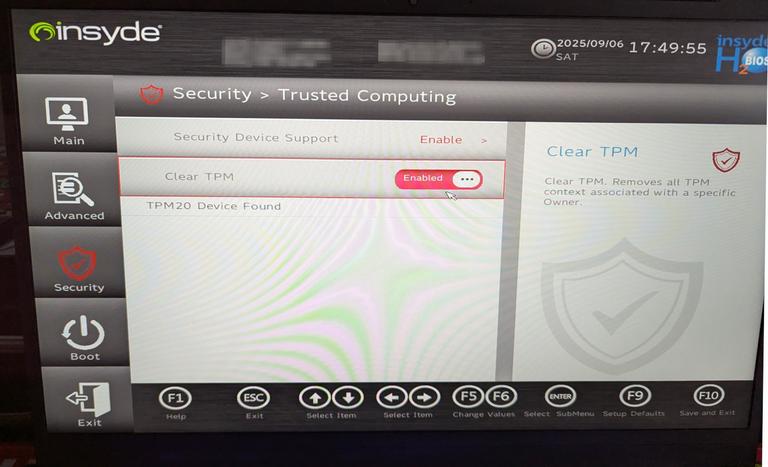 This is a photograph of a computer screen displaying a BIOS screen. At the top of the screen, there is a red banner indicating that we are looking at the “Security / Trusted Computing” section. Below this, the user's mouse pointer is focussing our attention on the toggle for “Clear TPM” which is found below a toggle labelled “Security Device Support”